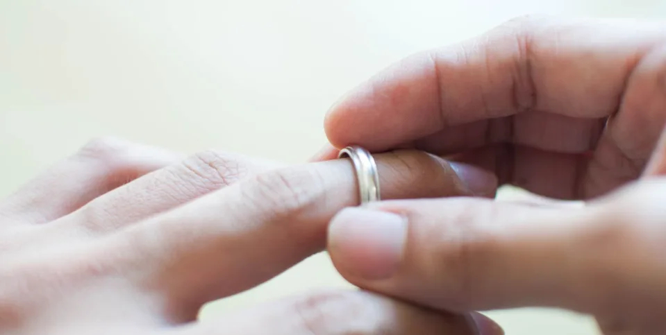person taking off their wedding ring